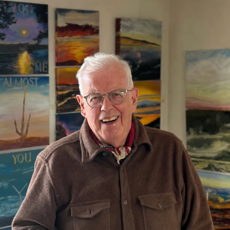 Ralph Reed in his studio with his paintings behind him